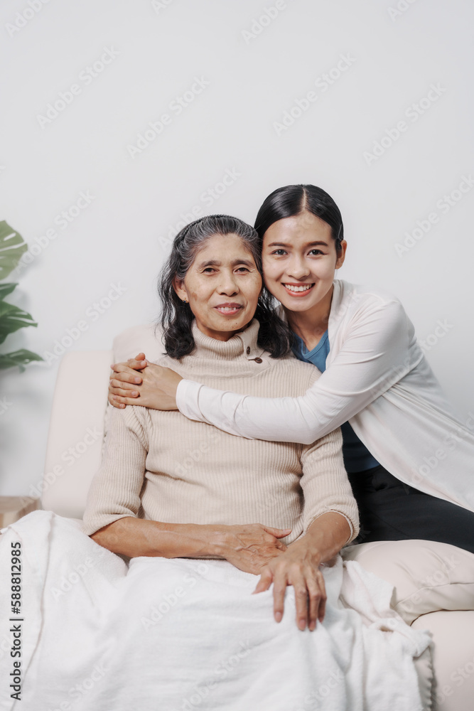 Hugging, love, valentine, care, Elderly mother with young daughter asia people only woman sitting on sofa at home have fun enjoying weekend together. Hugging, love, valentine, care, Elderly mother with young daughter asia people only woman sitting on sofa at home have fun enjoying weekend together.