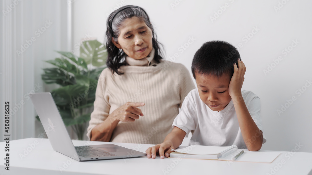 being reprimanded after getting low test scores, Asian grandson and grandmother people sitting together at desk. being reprimanded after getting low test scores, Asian grandson and grandmother people sitting together at desk.