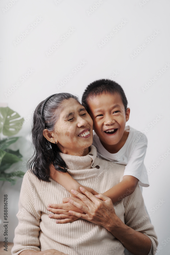 Hugging, love, valentine, Asian grandson and grandmother people sitting together at desk.
