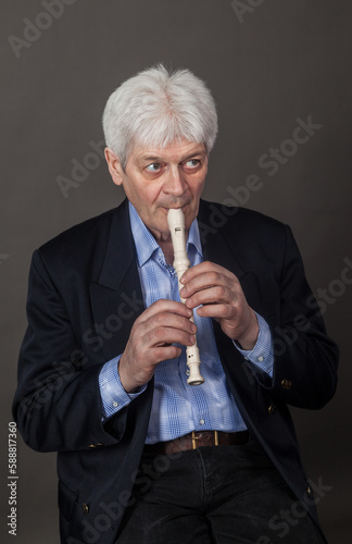 Portrait of an elderly musician with a pipe on a dark background. 