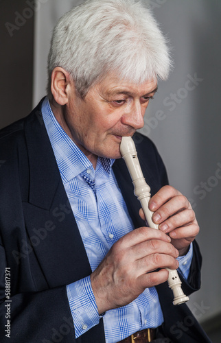 Portrait of an elderly musician with a pipe on a dark background. 