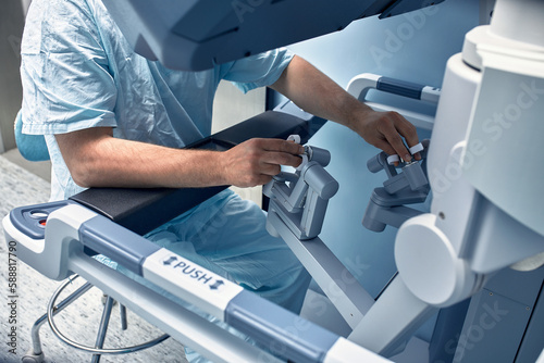 Tablou pe pânză Hands of a surgeon at a computer robot