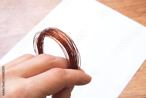 Coil of opper wire in hand closeup photo