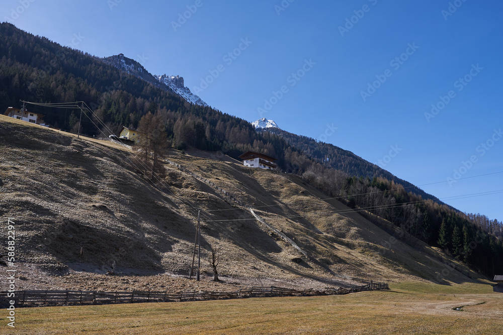 Fototapeta premium Neustift im Stubaital, Austria - March 16, 2023 - beautiful meadows and hillsides near Neustift at the end of the winter season 