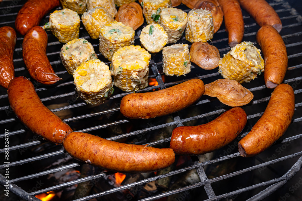 Baking sausages, sheeps cheese and corn on a metal grate fired with birch wood. Baking sausages, sheeps cheese and corn on a metal grate fired with birch wood.