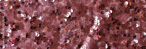 Soft pink cloth with colourful sequins abstract background