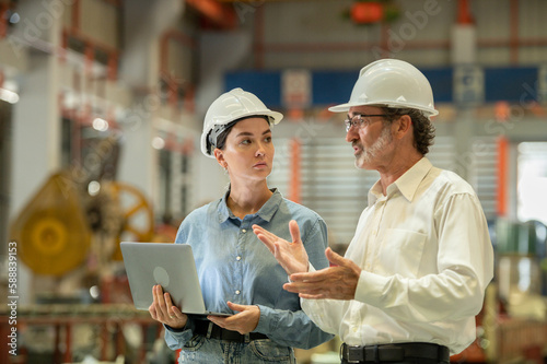 woman engineer assistant secretary in helmet inspection check control heavy machine construction installation in industrial factory with boss manager. Boss and partnership check maintenance factory