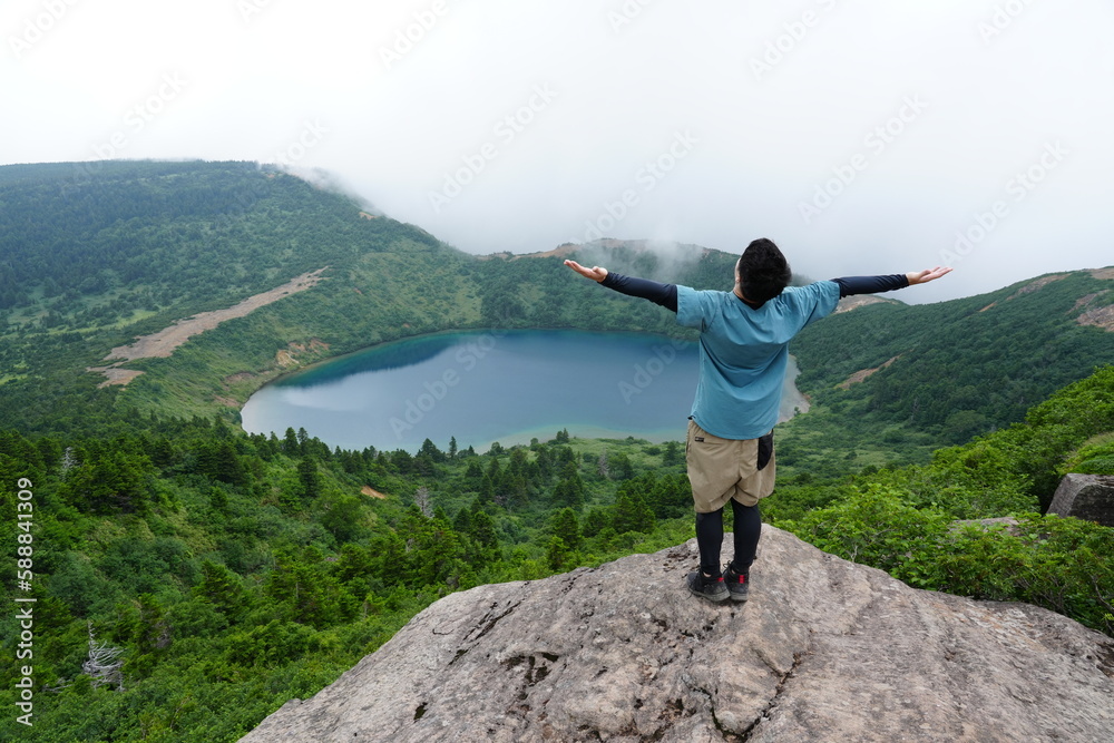 Obraz premium Happy Traveler with Arms Raised Watching Sunrise Above the Clouds