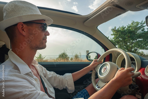 A young man is driving a car on the Greek island