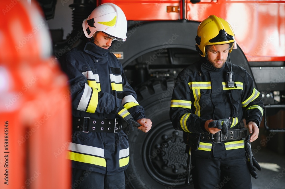 Fototapeta premium Portrait of two heroic fireman in protective suit and helmet.