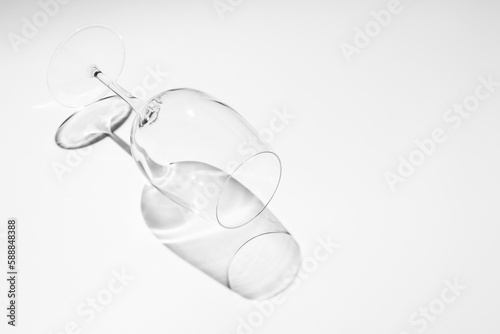 An empty wine glass lying on white background, copy space