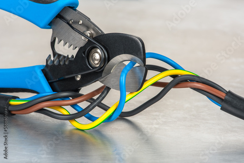 Cutting pliers and electrical cable on metal workshop table