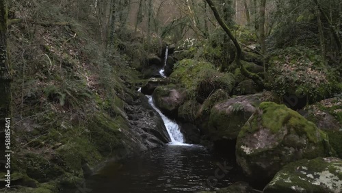 Aerial shot approxing to a small waterfall into the woods photo