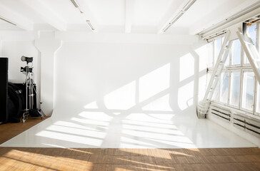 Large sunny photo studio with cyclorama and large panoramic windows.