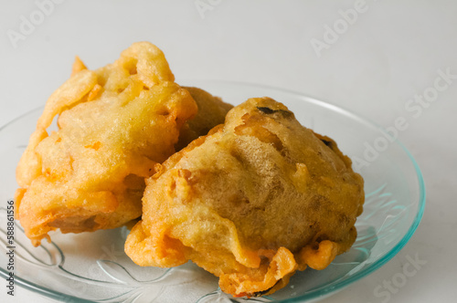 two pieces of fried tofu stuffed with vegetables served on a small plate isolated on a white background photo