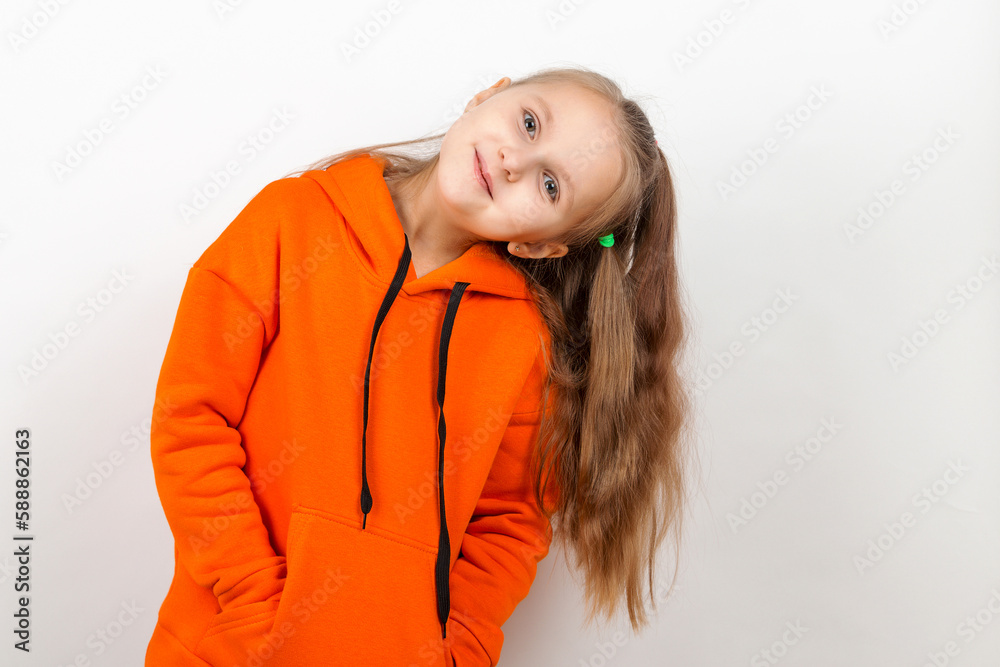 A little girl in an orange suit on a white background. He wriggles, shows emotions, smiles. A little girl in an orange suit on a white background. He wriggles, shows emotions, smiles.