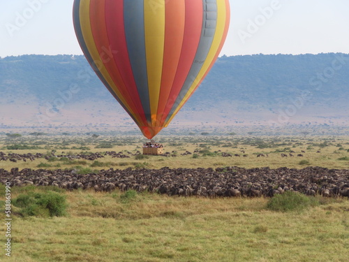 Hot air balloons with tourists above the Pilanesberg reserve. Three hot air balloons  decorated safari motifs against blue sky  mountains on background. Holiday Safari in South Africa