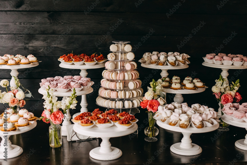 Naklejka premium Candy bar at a wedding. Sweet table with different handmade desserts in pink and white tones.