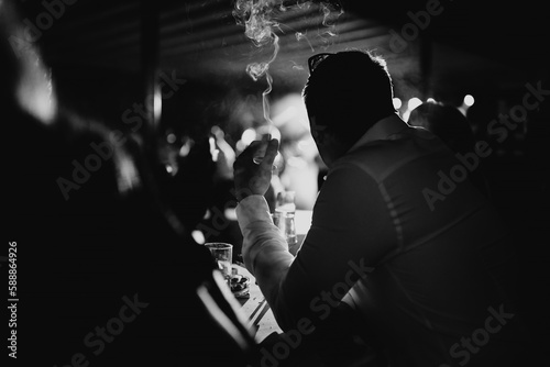 silhouette of a person at a bar smoking a cigarette.