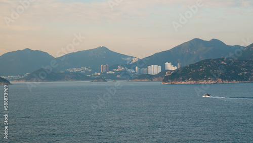 View of Hong Kong Island living quarter cityscape with many skyscraper buildings on the hills from Lamma Channel.