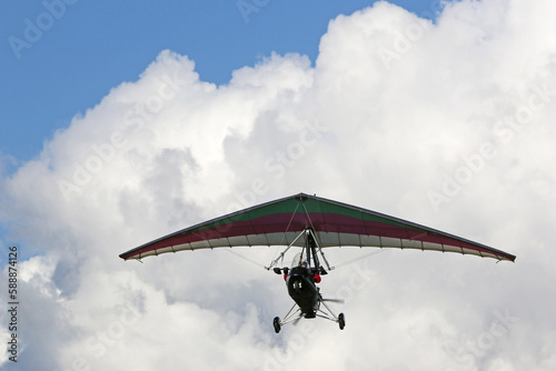 Canvas-taulu Ultralight airplane flying in a cloudy sky