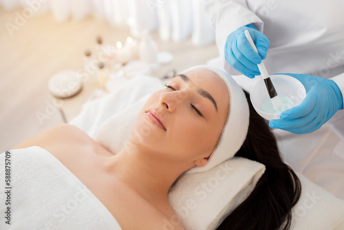 Relaxed indian woman getting skin treatment at modern spa salon