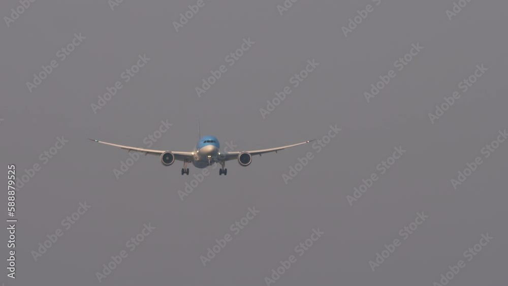 Civil plane approaching before landing. Commercial airplane flies, descending, front view. Long shot of airliner in the sky. Tourism and travel concept Civil plane approaching before landing. Commercial airplane flies, descending, front view. Long shot of airliner in the sky. Tourism and travel concept
