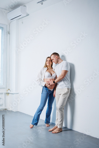 Happy married couple man and pregnant woman on white background in studio a pregnant woman and her husband. A married couple in love