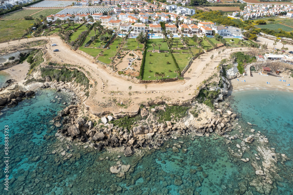 Drone aerial of holiday village with luxury houses at an idyllic rocky coast. Summer vacations at the sea. Protaras Cyprus
