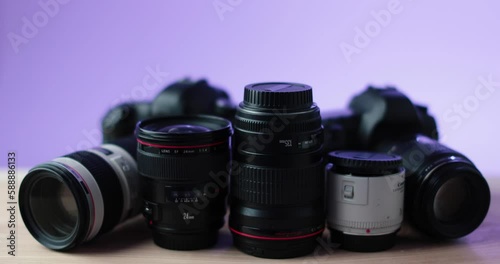 Camera and photo lense camera equipment with purple background in studio. High quality 4k footage
