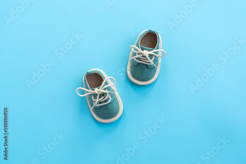 Baby shoes on paper background with copy space. Baby clothes concept. Top view, flat lay