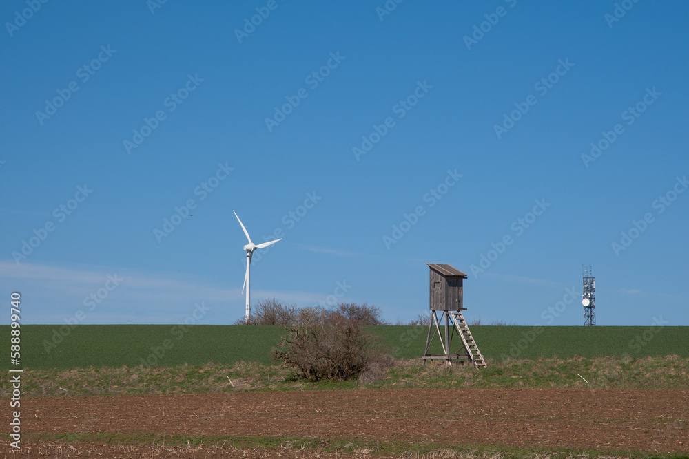 A hunting pulpit surrounded by wind turbines and transmission towers