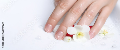 Spa treatment and product for female feet and hand spa, Thailand. Classic white wedding nail manicure with flowers. Spa treatment concept. Natural hygiene.