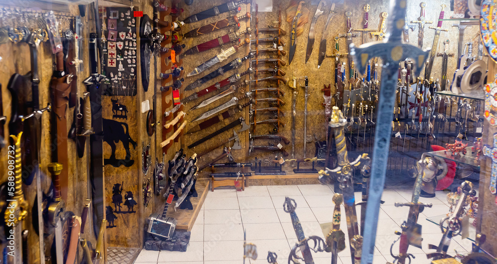 Showcases of Toledo souvenir shop with different old-fashioned weapons.