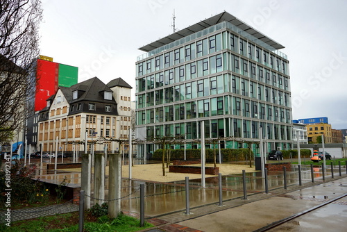 Heinz-Raspe-Platz mit Platanen und moderner Architektur bei Regen  an der Lindleystraße und dem Main Riedgraben im Ostend von Frankfurt am Main in Hessen photo