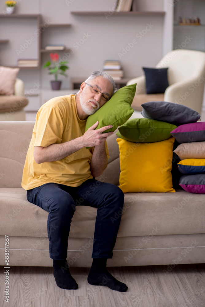 Old man with many pillows at home