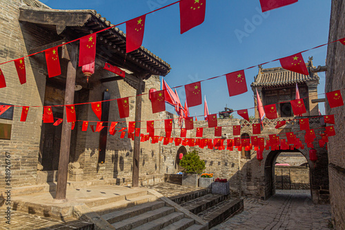 Alley with Chinese flags in Zhangbicun village, Shanxi province, China photo