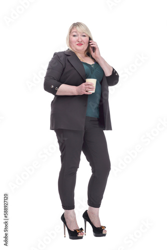 attractive mature woman with takeaway coffee talking on her mobile phone .