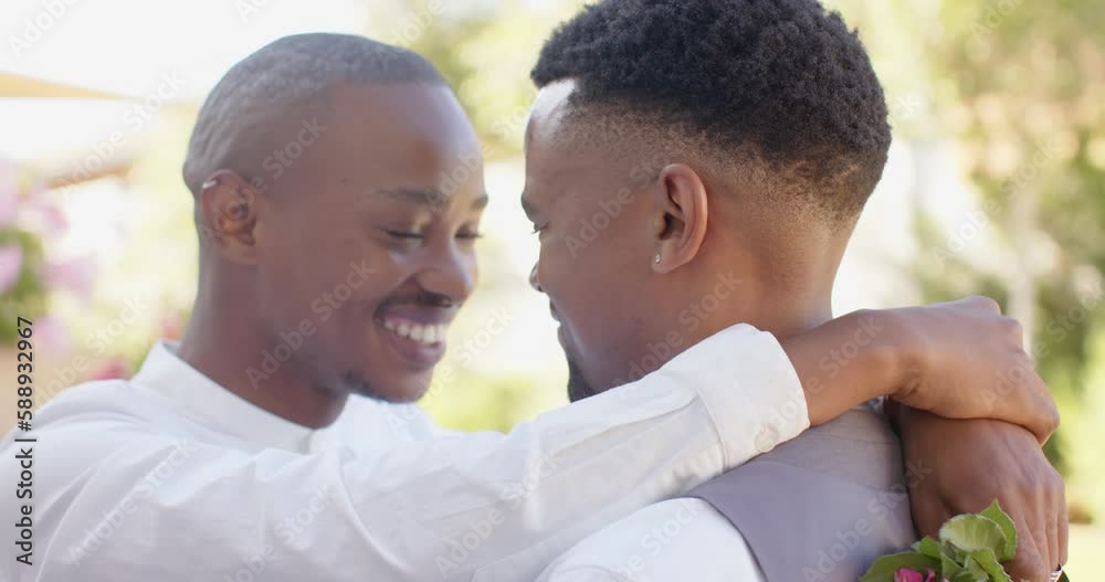 Happy african american gay male couple holding flowers and embracing at wedding, slow motion Happy african american gay male couple holding flowers and embracing at wedding, slow motion