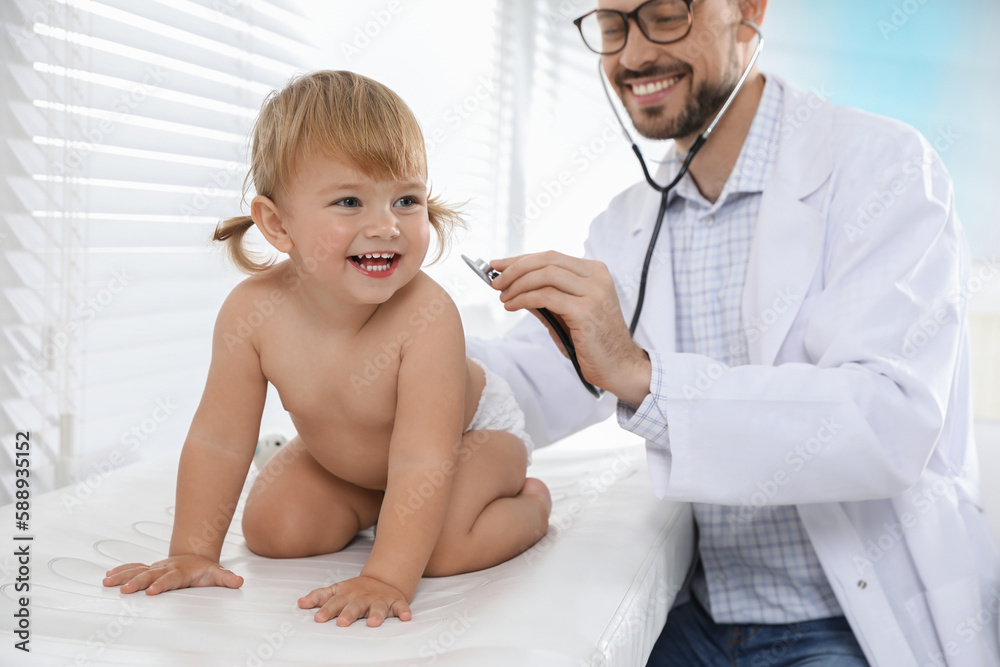Pediatrician examining baby with stethoscope in clinic Pediatrician examining baby with stethoscope in clinic