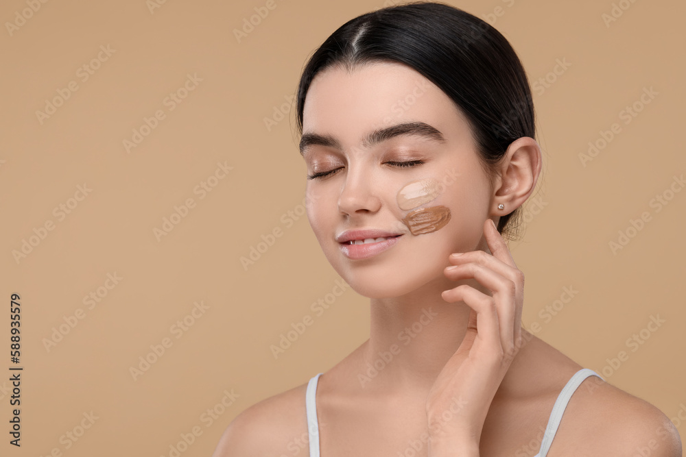 Teenage girl with swatches of foundation on face against beige background. Space for text Teenage girl with swatches of foundation on face against beige background. Space for text