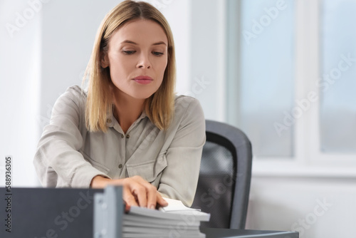 Businesswoman working with documents at table in office