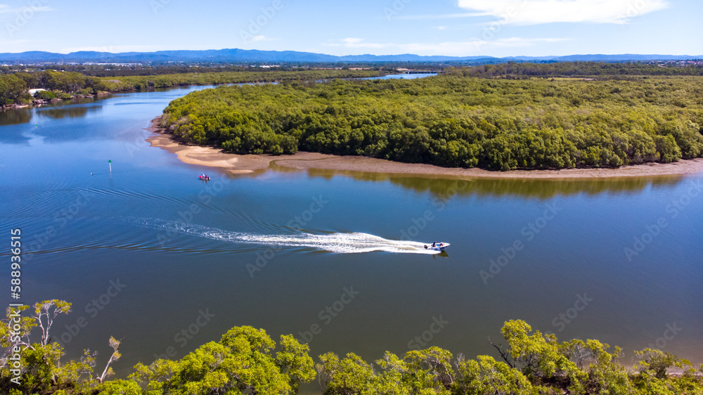 Beautiful famous Tinchi Tamba Wetlands, Bald Hills seen from above, spectacular wide river and speedboat. Shot from a drone, Brisbane, Queensland, Australia. 