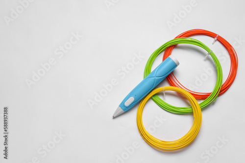 Stylish 3D pen and colorful plastic filaments on white background, flat lay, Space for text