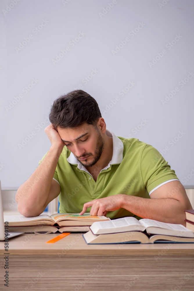 Young male student sitting in front of whiteboard Young male student sitting in front of whiteboard