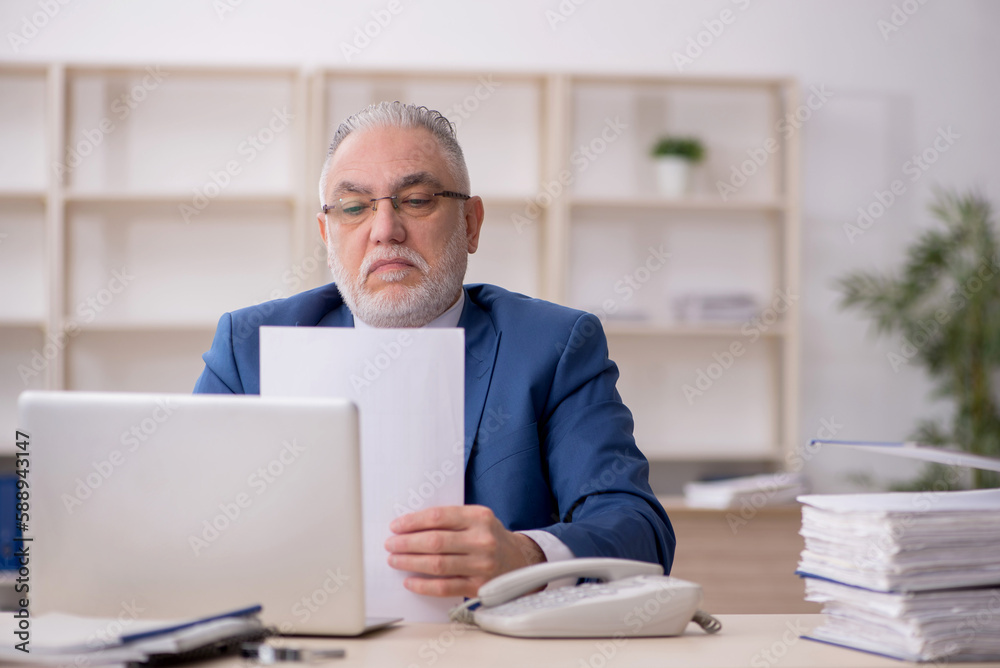 Old male employee and too much work at workplace Old male employee and too much work at workplace