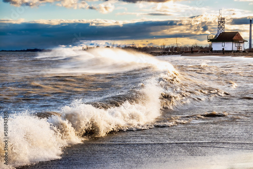 late afternoon sun on dramatic wind and waves breaking on a beach in toronto