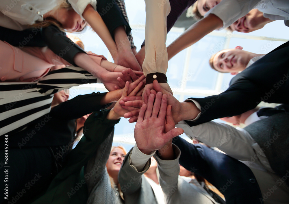 group of diverse young people folding their hands in a circle group of diverse young people folding their hands in a circle
