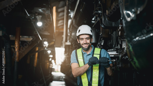 Portrait of Industrial engineer are working in the factory. Worker helping to repair and inspect the machine's readiness. Mechanical technicians are maintaining the engine in the train garage.