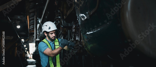 Engineer are working in the factory. Worker helping to repair and inspect the machine's readiness. Mechanical technicians are maintaining the engine in the train garage that is malfunctioning. © NewSaetiew